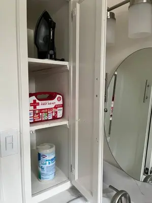 a white cabinet with a mirror and medicines in it at Lux Cozy Experience Elegance in San Bernardino