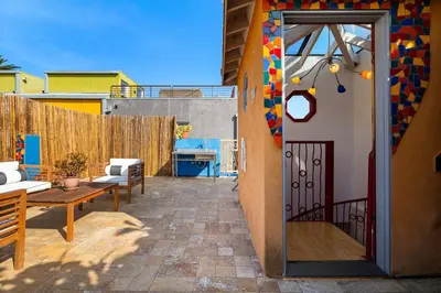 a door to a patio with a table and a bench at Artsy Venice Beach Canals Studio w/Rooftop & Sauna in Los Angeles