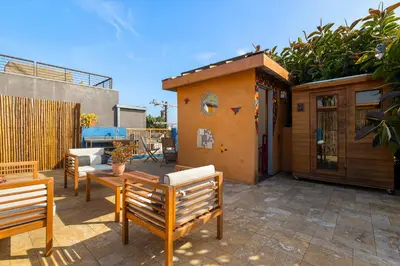 a patio with chairs and a table and a building at Artsy Venice Beach Canals Studio w/Rooftop & Sauna in Los Angeles