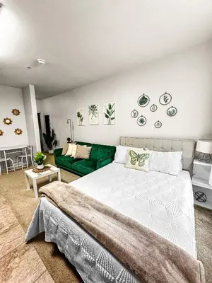 a bedroom with a bed and a green couch at Luxury ApartStudio Marina Del Rey Pool, Gym, Parking, Jacuzzi, BBQ in Los Angeles