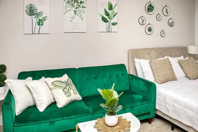 a living room with a green couch and a bed at Luxury ApartStudio Marina Del Rey Pool, Gym, Parking, Jacuzzi, BBQ in Los Angeles