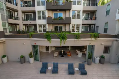an apartment building with chairs and tables in a courtyard at Luxury ApartStudio Marina Del Rey Pool, Gym, Parking, Jacuzzi, BBQ in Los Angeles