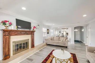 a living room with a fireplace and a tv at Furnished Patio! South Central Home 14 Mi to DTLA in Compton