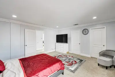 a bedroom with a bed and a tv and a chair at Furnished Patio! South Central Home 14 Mi to DTLA in Compton