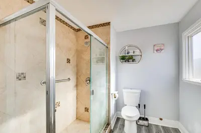 a bathroom with a shower and a toilet at Furnished Patio! South Central Home 14 Mi to DTLA in Compton