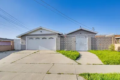 a house with a garage and a driveway at Furnished Patio! South Central Home 14 Mi to DTLA in Compton