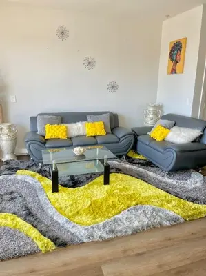 a living room with a couch and a yellow rug at 1 bedroom. 2 beds. 1 bath with Balcony in Los Angeles