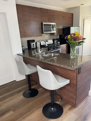 a kitchen with a counter with chairs and a counter top at 1 bedroom. 2 beds. 1 bath with Balcony in Los Angeles