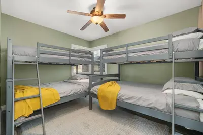 two bunk beds in a room with a ceiling fan at Newly Remodeled Home in the Heart of Orange County in Midway City