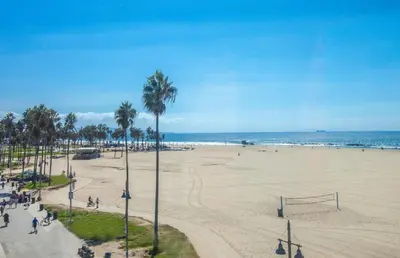 a view of a beach with palm trees and the ocean at Venice Breeze Suites in Los Angeles