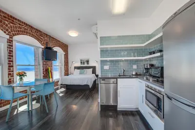 a kitchen and living room with a bed and a table at Venice Breeze Suites in Los Angeles