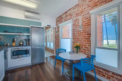 a kitchen with a brick wall and a table and chairs at Venice Breeze Suites in Los Angeles