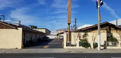 an empty street in a town with a fence at Hollywood Park Motel in Inglewood