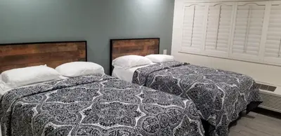 two beds sitting next to each other in a bedroom at Hollywood Park Motel in Inglewood