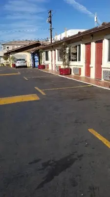 an empty parking lot in front of a building at Hollywood Park Motel in Inglewood