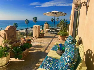 a balcony with a view of the ocean and a table at Malibu by the Sea - 5-STARS! in Solromar