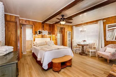 a bedroom with a bed and a table and chairs at Arrowhead Pine Rose Cabins in Twin Peaks