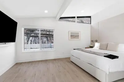 a white bedroom with a bed and two windows at Aquazzura - By Stay Awhile Villas in Malibu
