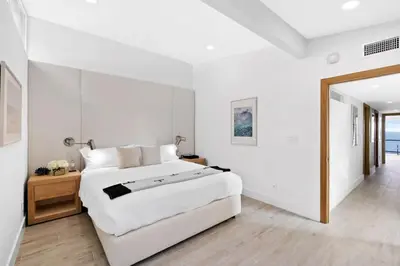 a white bedroom with a large bed and a mirror at Aquazzura - By Stay Awhile Villas in Malibu