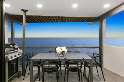 a table and chairs on a balcony with the ocean at Aquazzura - By Stay Awhile Villas in Malibu