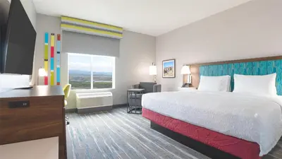 a hotel room with a bed and a desk and a television at Hampton Inn By Hilton Santa Clarita-Valencia in Santa Clarita