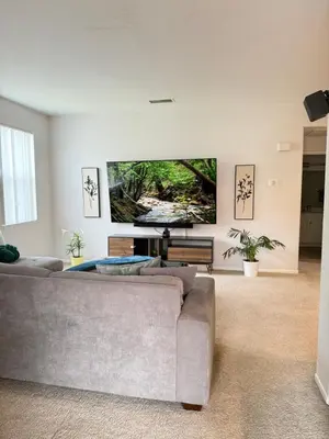 a living room with a couch and a large screen tv at Canyon Country Cozy Apartment, Pool and Jacuzzi in Santa Clarita