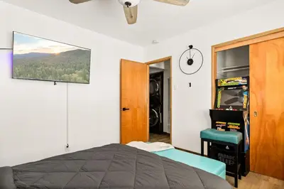 a bedroom with a bed and a television on the wall at Lil Oso Bonita Cabin in Big Bear Lake
