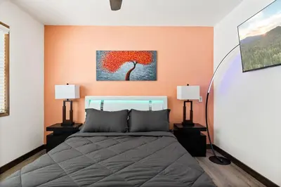 a bedroom with a bed and a painting of a tree at Lil Oso Bonita Cabin in Big Bear Lake