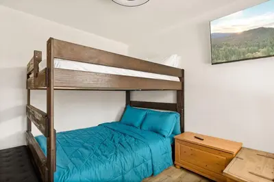 a bedroom with a bunk bed and a night stand at Lil Oso Bonita Cabin in Big Bear Lake
