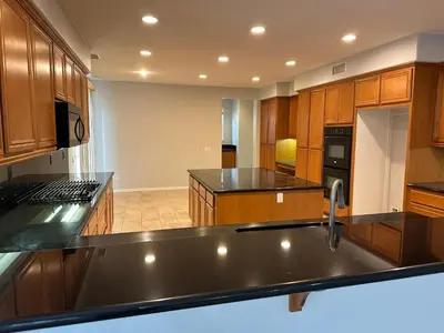 a large kitchen with wooden cabinets and a sink at ALE Displaced, Relocation, Insurance, Fire, Flood in Corona