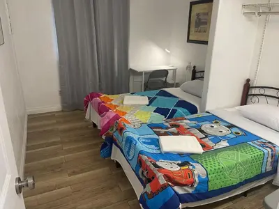 a bedroom with two beds with a hello kitty quilt at Walking Distance Disney in Anaheim in Anaheim