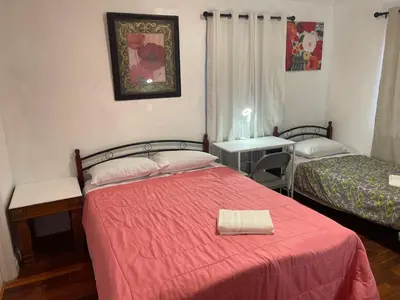a bedroom with two beds with a red blanket at Walking Distance Disney in Anaheim in Anaheim