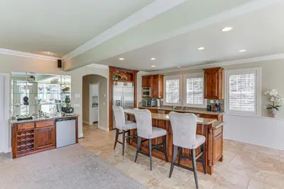 a kitchen with a bar with stools in it at Lake Arrowhead Home Mountain View, Walk to Water! in Lake Arrowhead