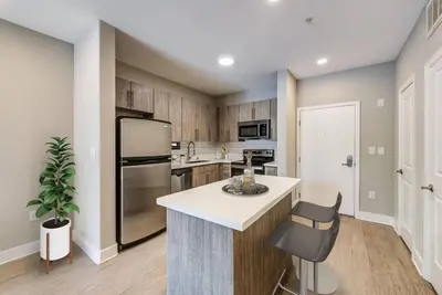 a kitchen with a refrigerator and a counter with a chair at Woodland Hills Luxury Apt 2 bed CA in Los Angeles