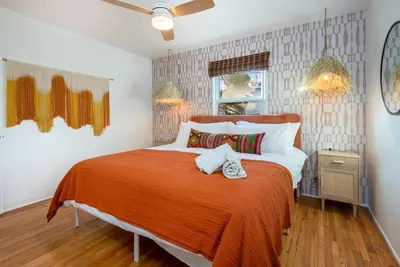 a bedroom with a large bed with an orange blanket at Luxe 1-bedroom Gem: Venice Beach Escape in Los Angeles