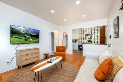 a living room with a couch and a surfboard on a table at Luxe 1-bedroom Gem: Venice Beach Escape in Los Angeles