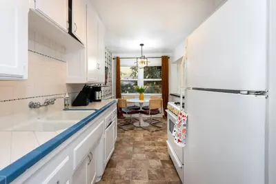 a kitchen with a white refrigerator and a table at Luxe 1-bedroom Gem: Venice Beach Escape in Los Angeles