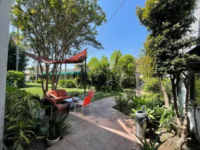 a patio with chairs and a table in a garden at Hotel Pacific Garden in Gardena