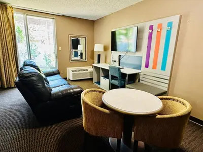 a living room with a table and a desk at Hotel Pacific Garden in Gardena