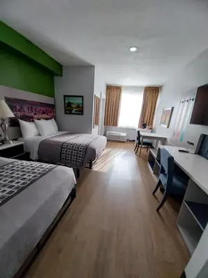 a hotel room with two beds and a desk at Hotel Pacific Garden in Gardena