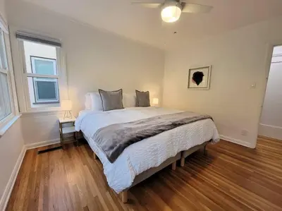 a bedroom with a large bed and two windows at Glamorous Getaway: Exclusive 1BR LA Hotspots in Los Angeles