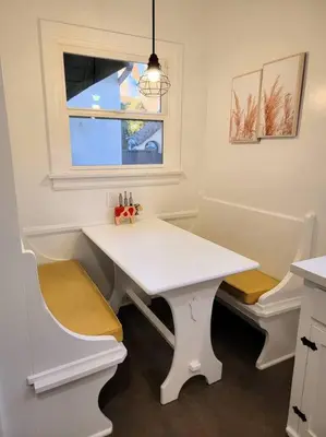 a white table and chairs in a kitchen with a window at Glamorous Getaway: Exclusive 1BR LA Hotspots in Los Angeles