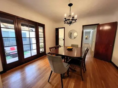 a dining room with a table and chairs and a chandelier at Glamorous Getaway: Exclusive 1BR LA Hotspots in Los Angeles