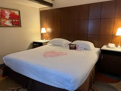 a large bed in a hotel room with two lamps at LA Crystal Hotel -Los Angeles-Long Beach Area in Carson