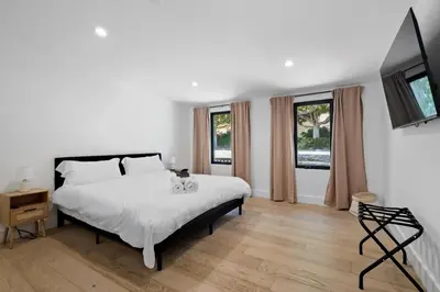 a bedroom with a white bed and two windows at Stunning Modern 5BR Family Mansion, Panoramic views of Penmar Golf, Pet Friendly! in Los Angeles