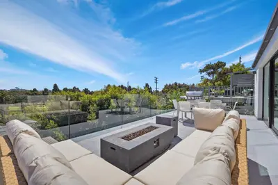 a patio with a couch and a fire pit at Stunning Modern 5BR Family Mansion, Panoramic views of Penmar Golf, Pet Friendly! in Los Angeles