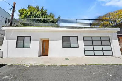 a white house with a balcony on top of it at Private Cozy Guest House, King Bed, Parking, Pet Friendly near Penmar Golf Course! in Los Angeles