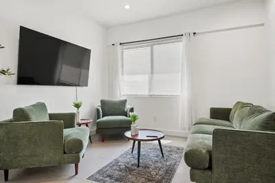 a living room with two couches and a tv at Private Cozy Guest House, King Bed, Parking, Pet Friendly near Penmar Golf Course! in Los Angeles