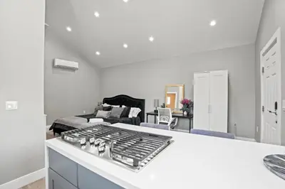 a white kitchen with a living room with a couch at New Modern Cozy Guest House, Parking, Pet Friendly in Mar Vista! in Los Angeles