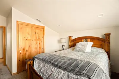 a bedroom with a wooden bed and a wooden door at Lakeside Paradise Escape in Big Bear Lake